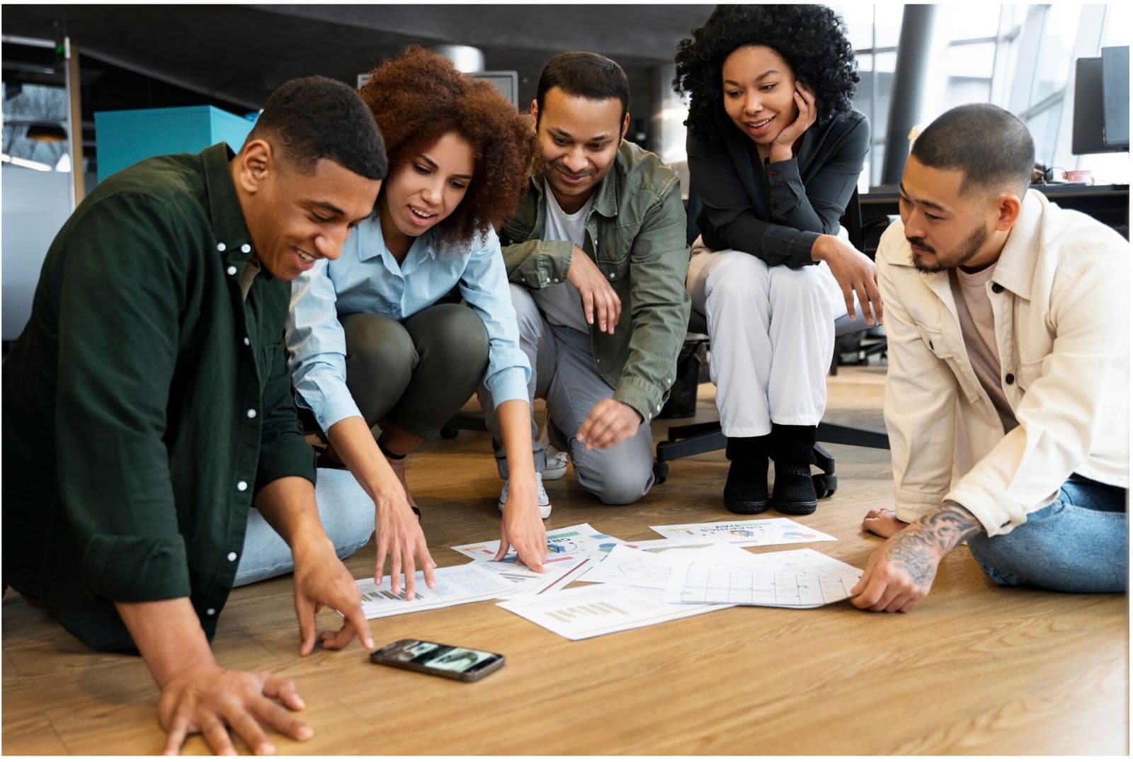 Connect Outsourcing team working through strategy printouts on the floor